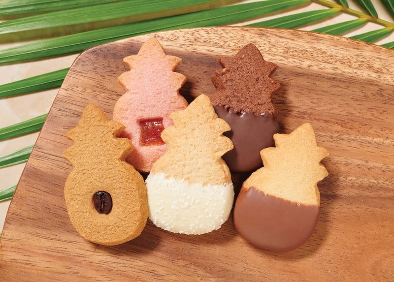 Pineapple-shaped cookies with various coatings.