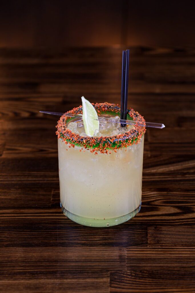 Spicy margarita with lime and straw.