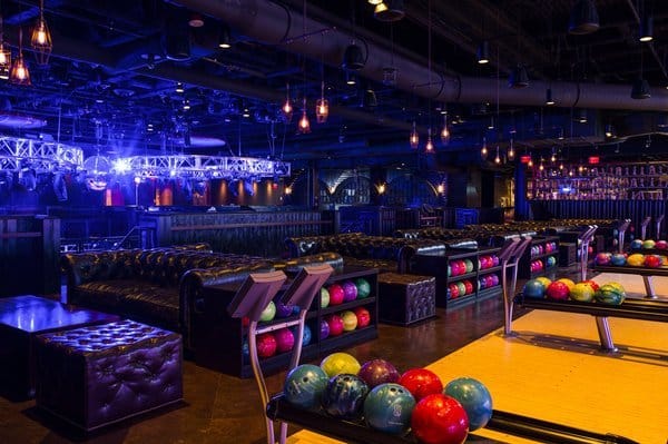 Bowling alley interior with colorful bowling balls and lounge seating.