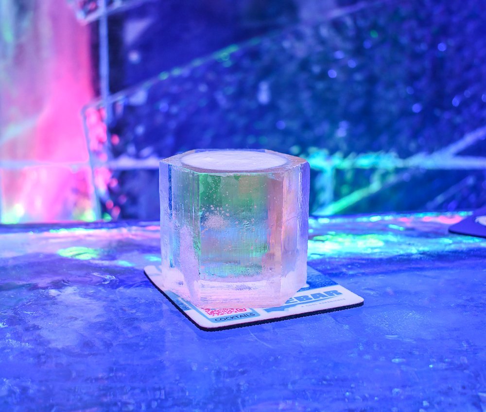 Clear glass on coaster with colorful reflections.