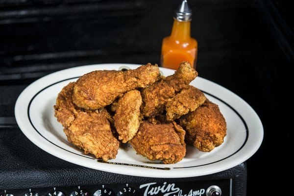 Fried chicken on a plate with hot sauce.