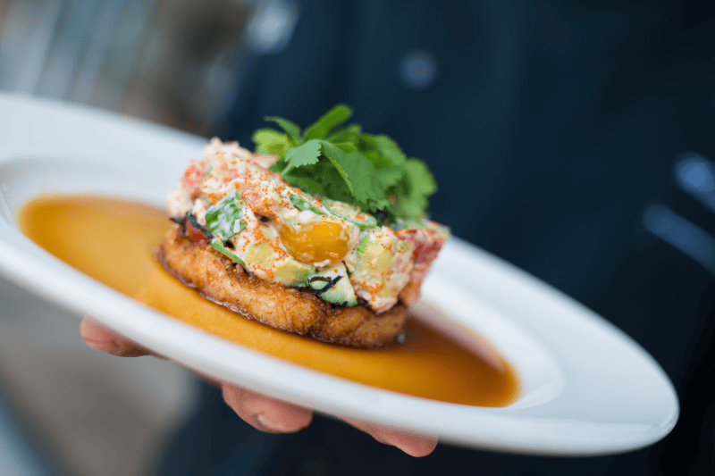 Close-up of food on a white plate held by a person.