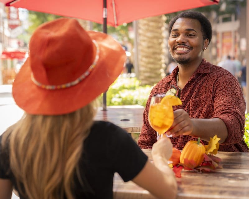 Couple toasting drinks outdoors.