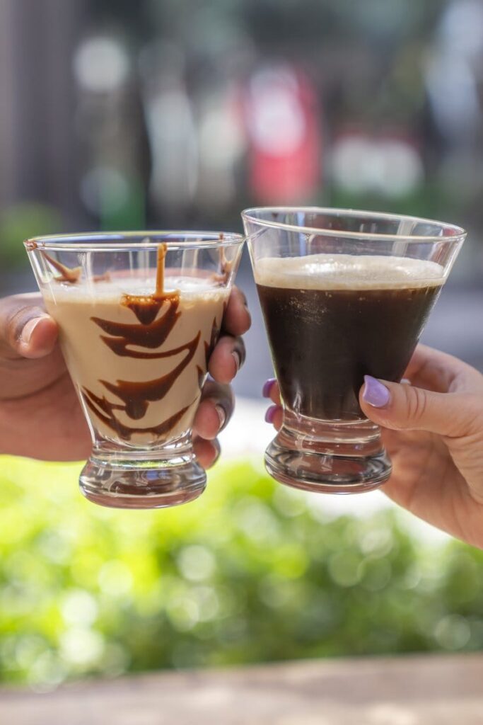 Two hands toasting with coffee cocktails.