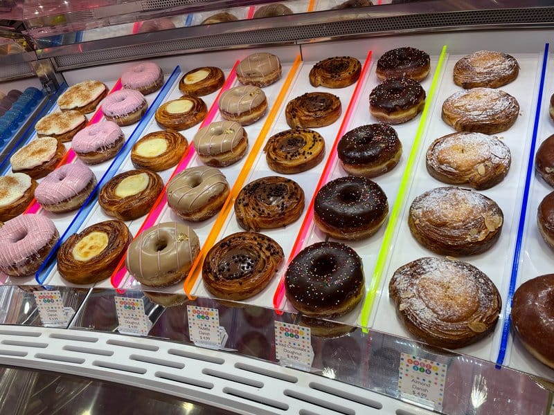 Assorted donuts on display shelves.