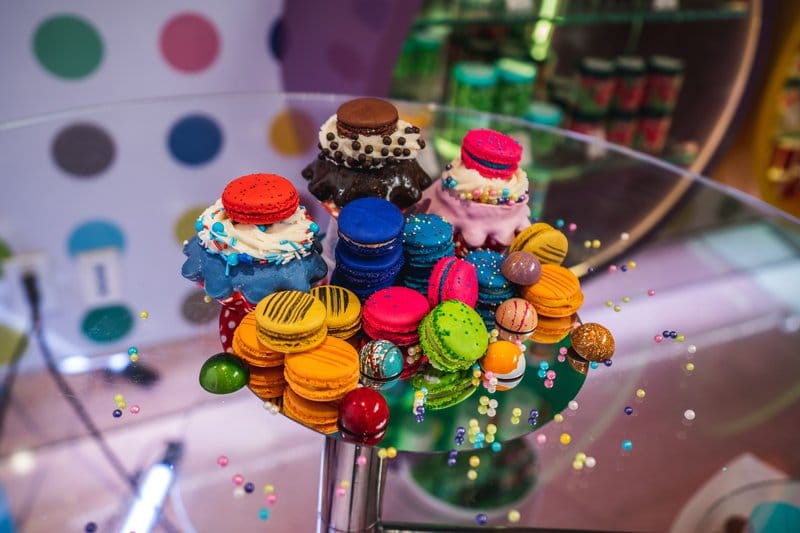 Colorful macarons displayed on a glass stand.