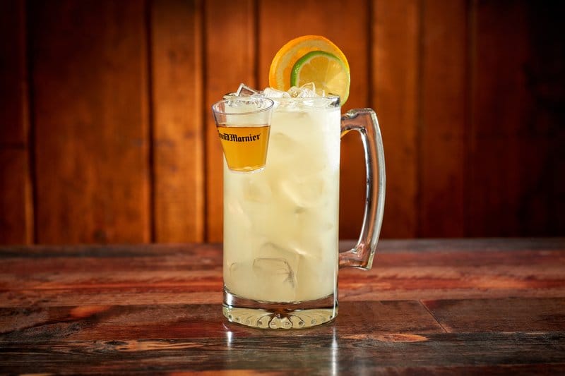 Tall cocktail with shot and lemon garnish.