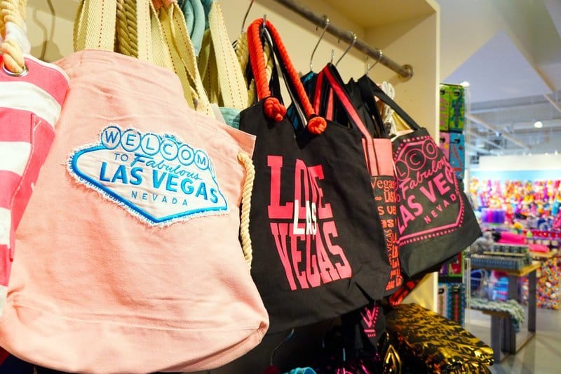Las Vegas souvenir apparel and tote bags on a rack.