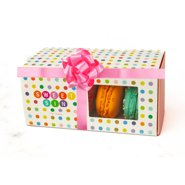 Macarons in polka dot gift box with pink ribbon.