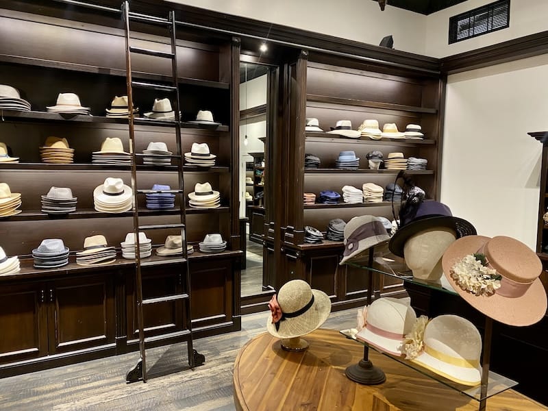 Hats displayed on shelves and mannequins in a boutique.